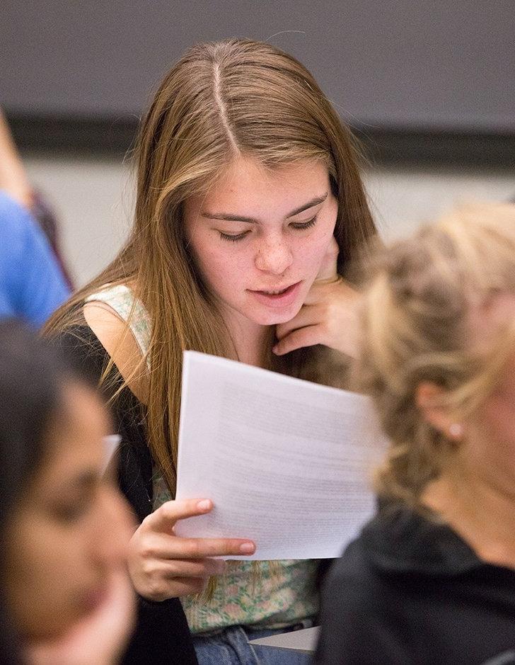  a students reads a handout in a classroom